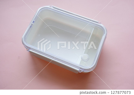 A simple, empty white plastic lunch box. 127877073