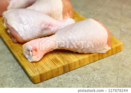 Raw chicken legs with pepper and spices on a board and plate ready for Raw chicken legs with pepper and spices on a board and plate ready for 127878244