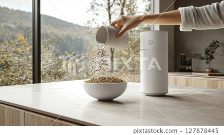 hand gracefully pours fresh kibble into designer pet bowl in softly lit kitchen modern bag of pet food rests in gentle background, highlighting clean aesthetic 127878445