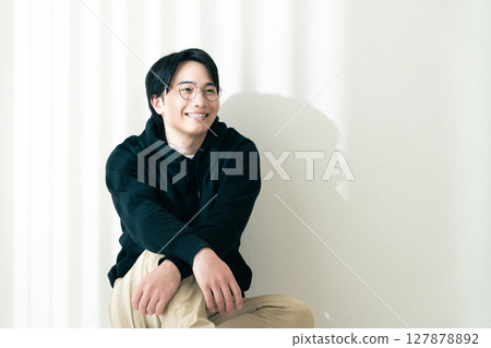 man sitting by the wall 127878892