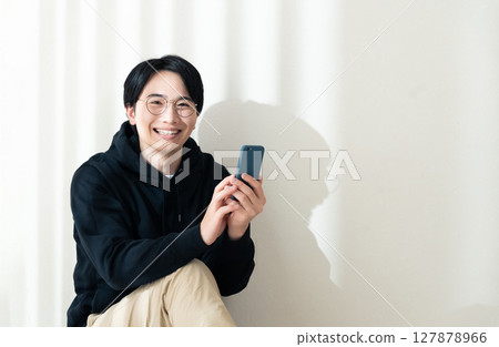A man seeing a smartphone at the wall 127878966