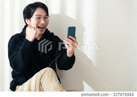 看見智能手機的一個人在牆壁 127878988