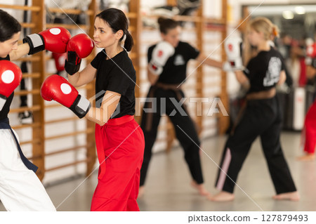 Young girl training boxing with partner during sports classes Young girl training boxing with partner during sports classes 127879493