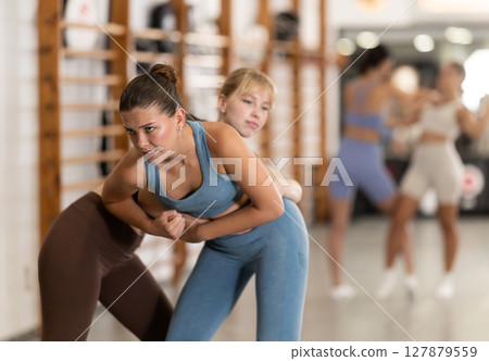 Young girl practicing self-defense techniques in pair 127879559