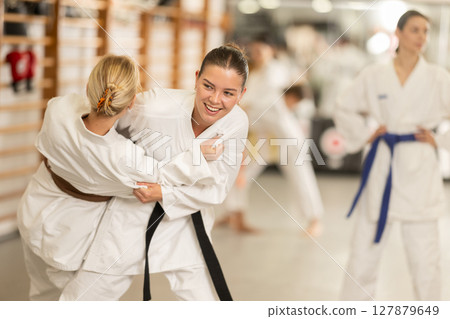 Women in kimono exercising in pairs during training 127879649