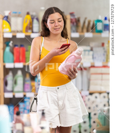 Young woman scanning qr code for detergent Young woman scanning qr code for detergent 127879729