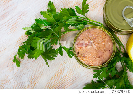 Canned tuna with parsley and lemon on a wooden table 127879738