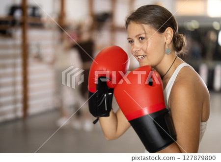 Young girl posing with boxing gloves Young girl posing with boxing gloves 127879800