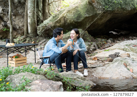 Couple Camping and Enjoying Quality Time by the Stream Couple Camping and Enjoying Quality Time by the Stream 127879827