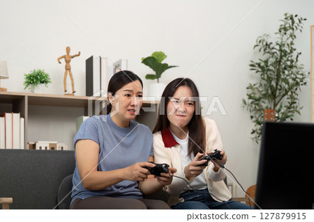 Focused Mother and Daughter Competing in Video Games 127879915
