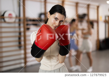 Woman in red boxing gloves in gym 127879923