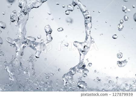 水濺在灰色的背景上。 127879939