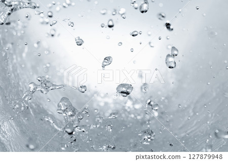 Water splashes on a blue background. 127879948