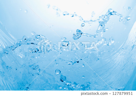 水濺在藍色背景上。 127879951