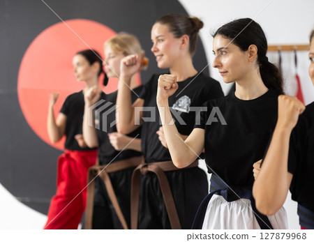 Side view of young women during karate classes Side view of young women during karate classes 127879968