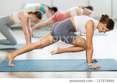 Group of young women doing pilates exercises Group of young women doing pilates exercises 127879988