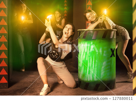 Girls play laser tag, jokingly fight with light weapons Girls play laser tag, jokingly fight with light weapons 127880011