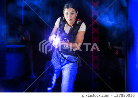 Girl play laser tag, jokingly fight with light weapons in dark room Girl play laser tag, jokingly fight with light weapons in dark room 127880036