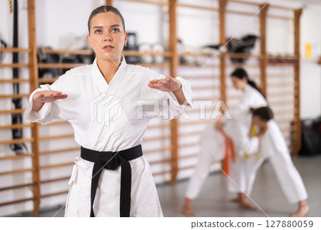Young woman doing warm-up before karate training 127880059