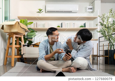 Gay couple enjoying time together while unpacking at home 127880079