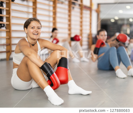 women doing abdominal exercise in boxing gloves women doing abdominal exercise in boxing gloves 127880083