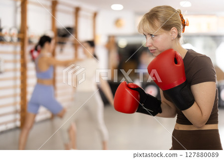 Woman in red boxing gloves in gym 127880089