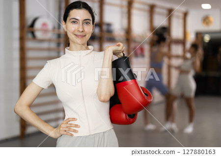 Woman in red boxing gloves in gym 127880163