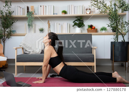 Yoga and Mindfulness. Woman practicing yoga in her living room with a corgi. 127880178