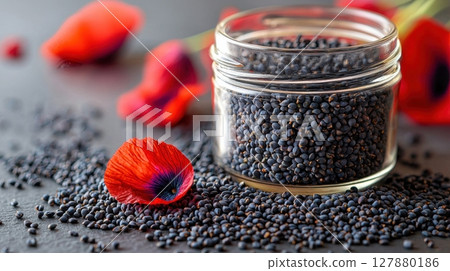 deep black poppy seeds fill clear jar next vibrant red petal on white surface, creating striking visual contrast showcases simplicity and beauty 127880186