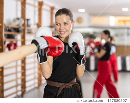 Women fight with hands, using all strength, courage during boxing lesson Women fight with hands, using all strength, courage during boxing lesson 127880207
