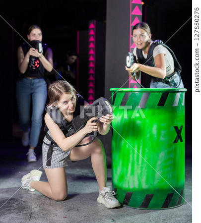 Girls play laser tag, jokingly fight with light weapons Girls play laser tag, jokingly fight with light weapons 127880276