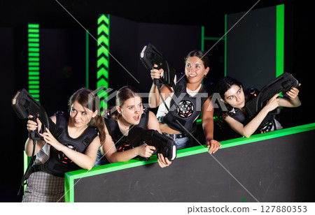 Girls play laser tag, jokingly fight with light weapons Girls play laser tag, jokingly fight with light weapons 127880353