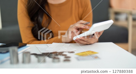 Expense Tracking and Budgeting. Woman using calculator for personal finance. 127880388