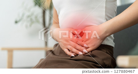 Health Awareness: Young Woman Holding Stomach in Pain 127880467