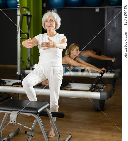 Woman doing exercises on Pilates chair 127880486