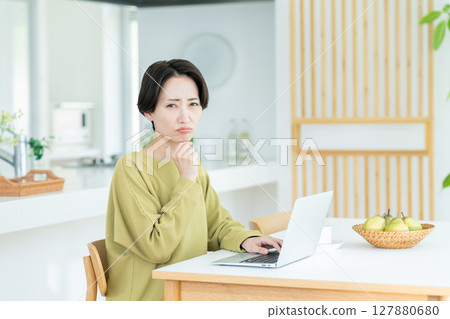 Middle-aged woman worried about her computer 127880680