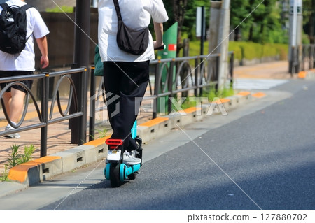 An electric kick scooter running on the road An electric kick scooter running on the road 127880702
