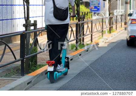 An electric kick scooter running on the road An electric kick scooter running on the road 127880707