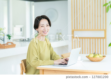 Middle-aged woman using a computer at home Middle-aged woman using a computer at home 127881200