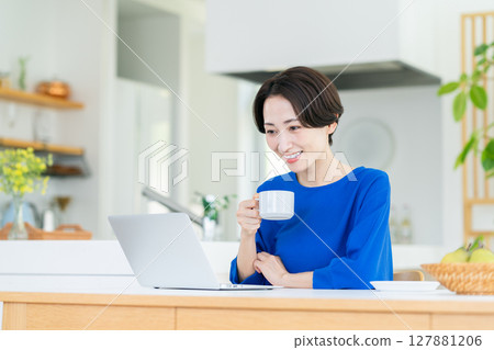Middle-aged woman using a computer at home 127881206