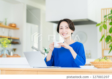 Middle-aged woman using a computer at home 127881207