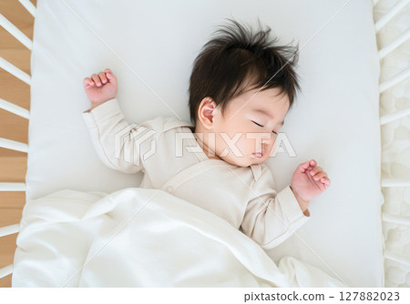 Baby sleeping soundly in a crib 127882023