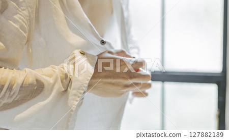 A man taking off a wet shirt, buttons, undressing 127882189