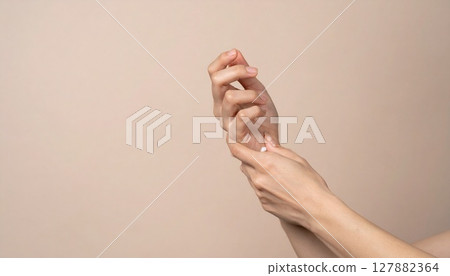 Close-up of a hand applying lotion to fingers 127882364