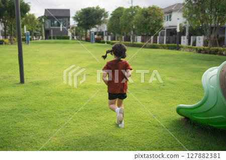 Joyful Child Running in Park with Vibrant Green Grass and Play Equipment, Bright Sunny Day, Outdoor Activity, Happiness and Freedom Experience Joyful Child Running in Park with Vibrant Green Grass and Play Equipment, Bright Sunny Day, Outdoor Activity, Happiness and Freedom Experience 127882381