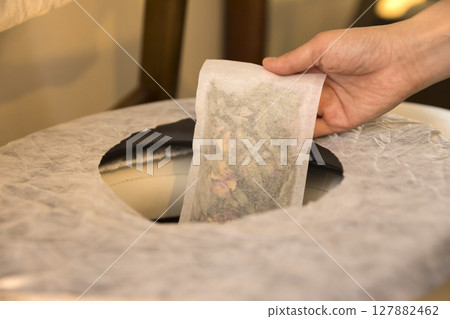 Woman's hands preparing for mugwort steaming Woman's hands holding a mugwort pack Woman's hands preparing for mugwort steaming Woman's hands holding a mugwort pack 127882462