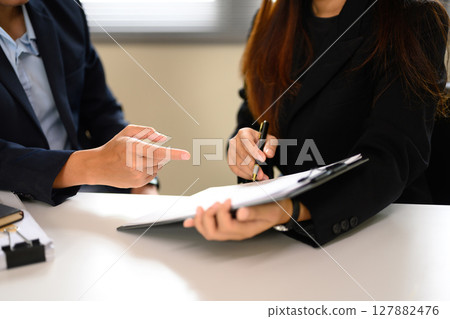 Close up of business professionals discussing contract details at the office table 127882476