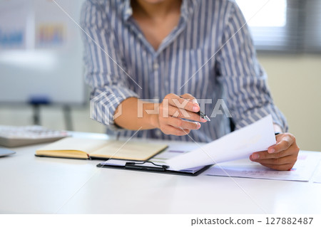Businessman going through financial or business reports in a clean workspace Businessman going through financial or business reports in a clean workspace 127882487