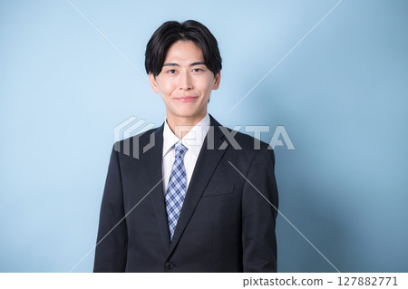 一位年輕的商人穿著西裝看著鏡頭，淺藍色，令人耳目一新的形象 127882771