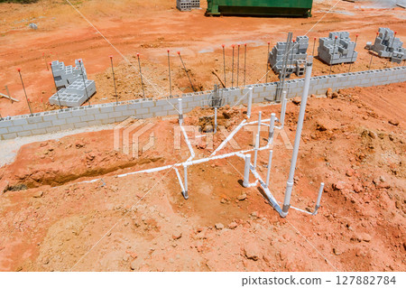 Workers are laying foundation, installing plumbing pipes at building site on works day. Workers are laying foundation, installing plumbing pipes at building site on works day. 127882784
